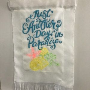 Garden flag embroidered on white polyester burlap.